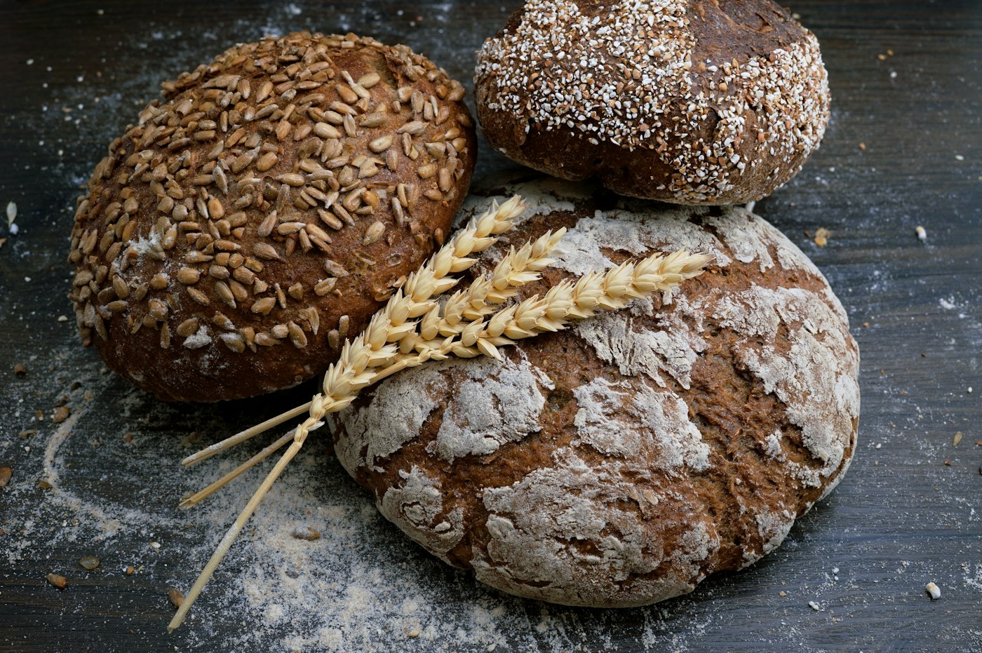 Ambachtelijk brood met tarwearen op houten tafel