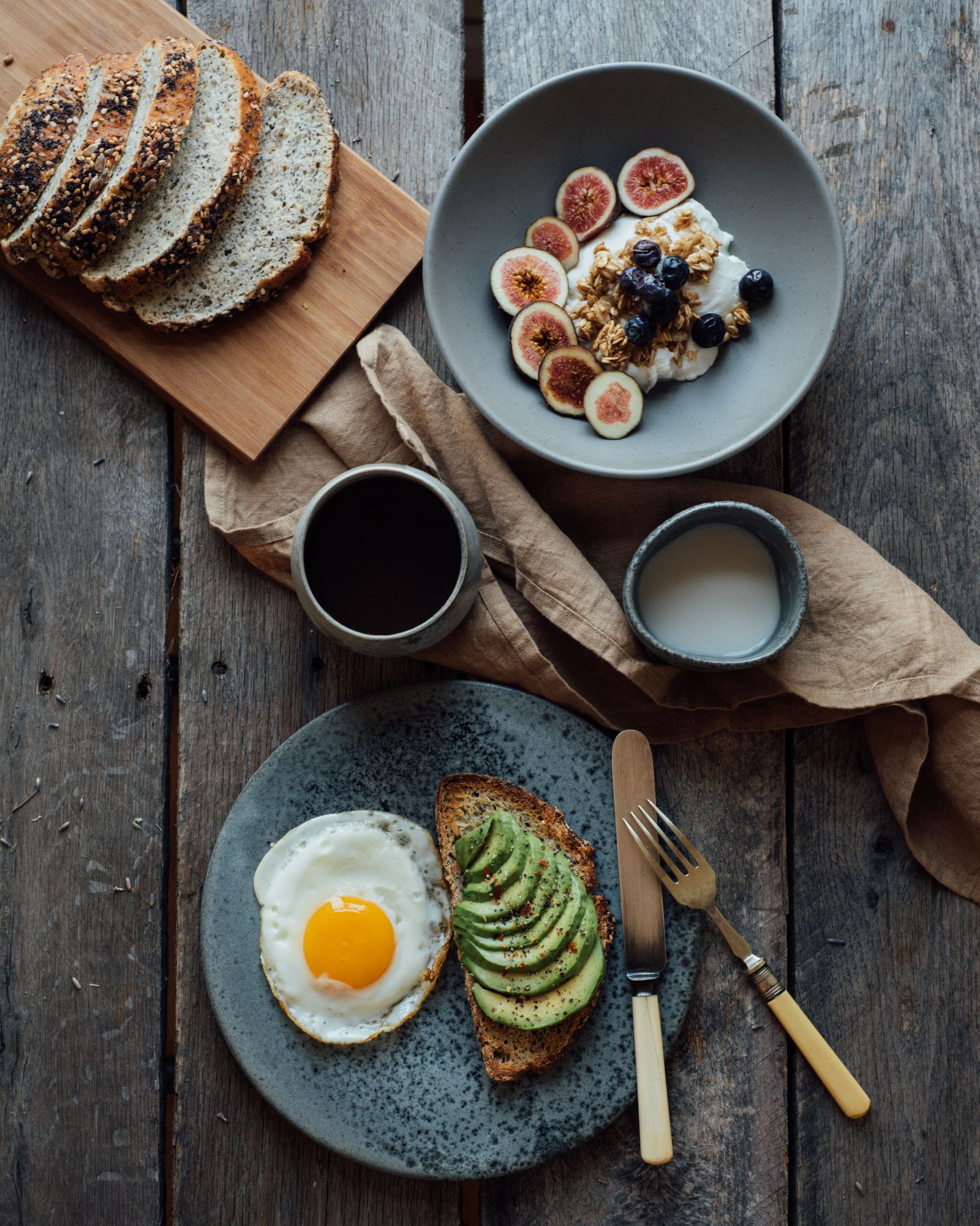Houten tafel met keramiek, brood en ochtendlicht
